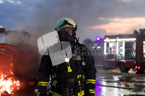 Image of Portrait of a heroic fireman in a protective suit. Firefighter in fire fighting operation.