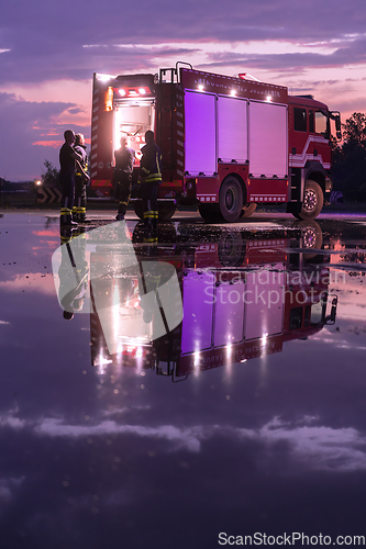 Image of Fire truck emergency vehicle. Firefighting apparatus and water to save lives, suppress wildfire, extinguish building fires and assist vehicle collisions or traffic car crash accidents.
