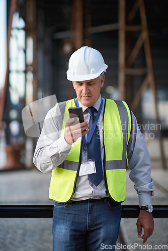 Image of Construction, engineer and man with a phone outdoor for building project management contact. Contractor person with helmet and smartphone for civil engineering, safety and development communication