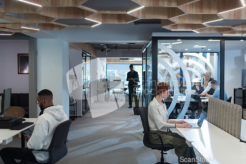 Image of Young group of business people brainstorming together in a startup space, discussing business projects, investments, and solving challenges.