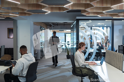 Image of Young group of business people brainstorming together in a startup space, discussing business projects, investments, and solving challenges.