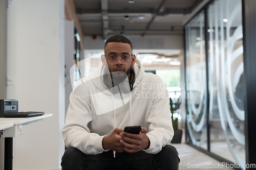 Image of In a modern office setting, an African American businessman is diligently working on his laptop, embodying determination, ambition, and productivity in his professional environmen