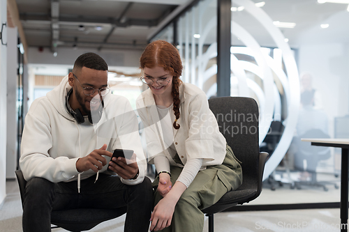 Image of In a modern office African American young businessman and his businesswoman colleague, with her striking orange hair, engage in collaborative problem-solving sessions