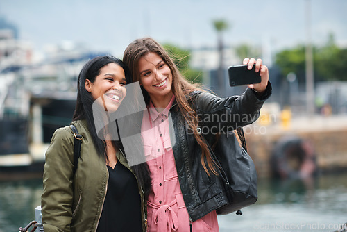 Image of Selfie, travel and diversity with tourist friends taking a picture outdoor together in a foreign city abroad. Happy, smile or bonding with a female and friend posing for a photograph overseas