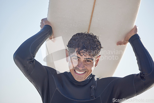 Image of Portrait, surf and man surfer with surfboard at the beach, sea or ocean with a smile and is happy on a summer day. Exercise, surfing and male with swimsuit in Australia with freedom on the waves