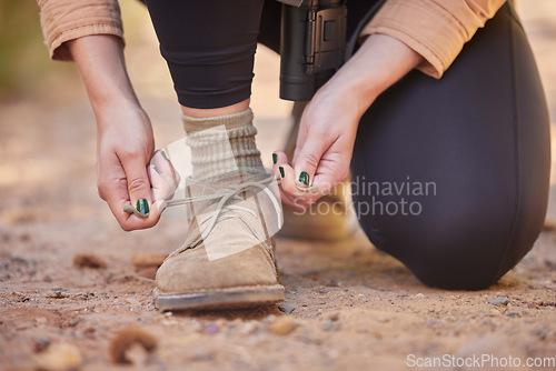 Image of Shoes, hiking and woman tying laces to start a walk, adventure or trekking in nature of Norway. Ready, active and feet and hands of a girl walking on ground in the mountains for exercise and cardio