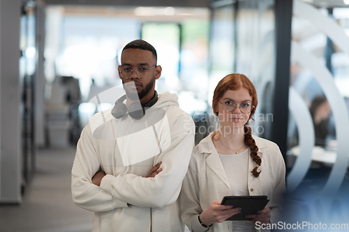 Image of In a modern office African American young businessman and his businesswoman colleague, with her striking orange hair, engage in collaborative problem-solving sessions