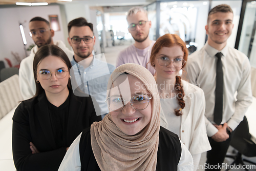 Image of A group of young business professionals stands together, taking a well-deserved break from their busy workday, showcasing camaraderie, teamwork, and a moment of relaxation in their dynamic workplace