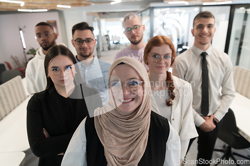 Image of A group of young business professionals stands together, taking a well-deserved break from their busy workday, showcasing camaraderie, teamwork, and a moment of relaxation in their dynamic workplace