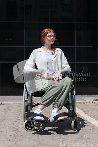 Image of In front of a modern corporate building, a young woman sitting in a wheelchair confidently, symbolizing empowerment, inclusivity, and the strength to overcome challenges in the business world