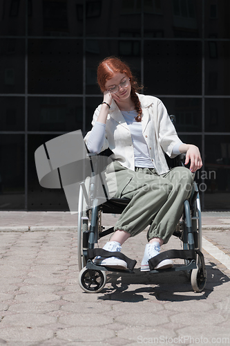 Image of In front of a modern corporate building, a young woman sitting in a wheelchair confidently, symbolizing empowerment, inclusivity, and the strength to overcome challenges in the business world