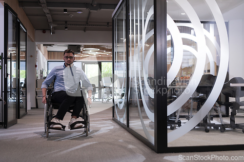 Image of In a large modern corporation, a determined businessman in a wheelchair navigates through a hallway, embodying empowerment and inclusivity in the corporate world.