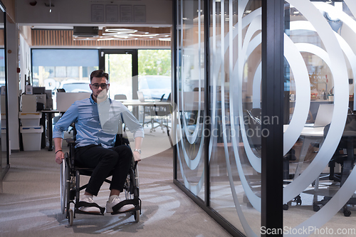 Image of In a large modern corporation, a determined businessman in a wheelchair navigates through a hallway, embodying empowerment and inclusivity in the corporate world.