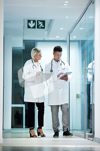 Image of Tablet, collaboration and doctors talking planning a surgery in a modern hospital in discussion of diagnosis together. Man, woman and healthcare professionals brainstorming at a clinic using internet