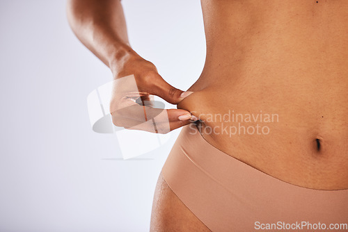 Image of Fat, lose weight and woman touching stomach in studio with liposuction mockup, space and background. Skin, cellulite and hands check muscle, body and diet for abdomen, wellness health and tummy tuck