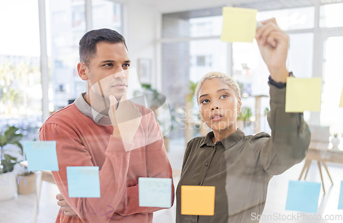 Image of Creative people, planning and thinking for schedule, team strategy or brainstorming on glass wall at office. Man and woman in teamwork contemplating plan, tasks and post it for sticky note or startup