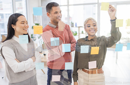 Image of Creative people, schedule and team in planning strategy or brainstorming on glass wall at office. Group in teamwork with smile for project plan, tasks and post it for sticky note or startup together