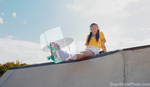 Image of Sports, music and rollerblades with woman in skate park for summer break, streaming and mockup. Fitness, peace and skating with girl listening to headphones in outdoors for hobby, freedom and peace