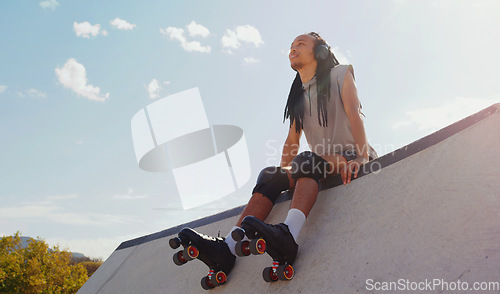 Image of Music, relax and man rollerskating at a park, thinking and sitting in peace in Australia. Freedom, idea and person planning to skate on a ramp with audio from headphones for motivation in nature