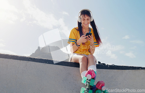 Image of Relax, phone and music with woman and rollerblades for skating, streaming and social media app. Technology, headphones and sports with girl in skate park for internet, mobile radio and fitness