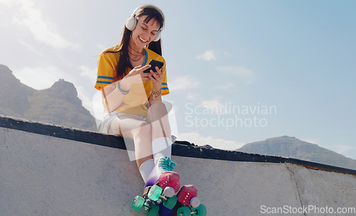 Image of Smile, phone and music with woman and roller skates for skating, streaming and social media app. Technology, headphones and sports with girl in skate park for internet, mobile radio and fitness