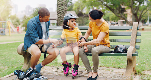 Image of Family, rollerskate and interracial parents help kid with safety pads teaching her skating at the park and bonding outdoors. Mother, father and daughter learning to skate from mom and dad