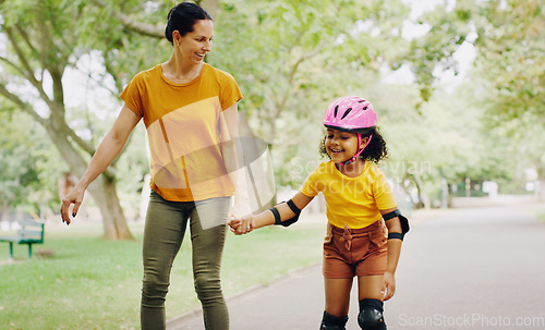 Image of Mom, park and holding hands to rollerskate with child with care, learning and support. Interracial parent, teaching and woman with girl kid, smile and helping hand on road for skating on vacation