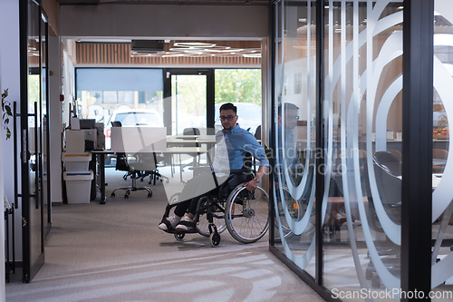 Image of In a large modern corporation, a determined businessman in a wheelchair navigates through a hallway, embodying empowerment and inclusivity in the corporate world.