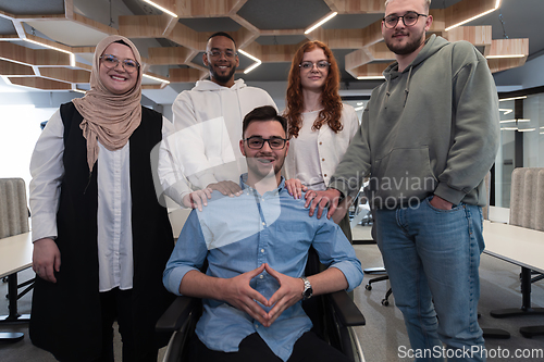 Image of Young businessmen in a modern office extend a handshake to their business colleague in a wheelchair, showcasing inclusivity, support, and unity in the corporate environment.