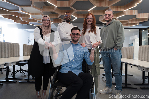 Image of Young businessmen in a modern office extend a handshake to their business colleague in a wheelchair, showcasing inclusivity, support, and unity in the corporate environment.