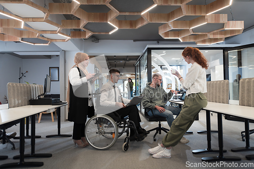 Image of Young group of business people brainstorming together in a startup space, discussing business projects, investments, and solving challenges.