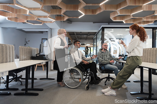 Image of Young group of business people brainstorming together in a startup space, discussing business projects, investments, and solving challenges.