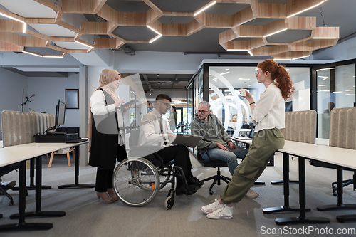 Image of Young group of business people brainstorming together in a startup space, discussing business projects, investments, and solving challenges.