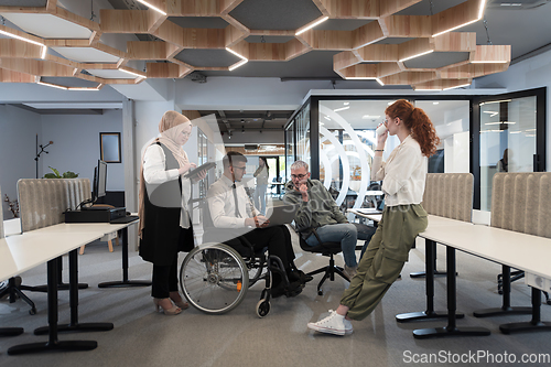 Image of Young group of business people brainstorming together in a startup space, discussing business projects, investments, and solving challenges.