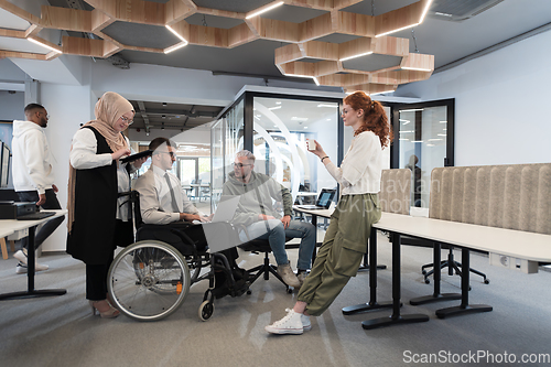 Image of Young group of business people brainstorming together in a startup space, discussing business projects, investments, and solving challenges.