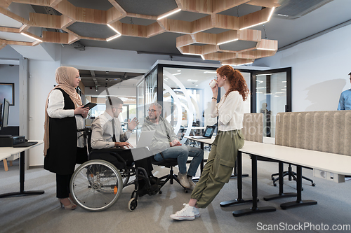 Image of Young group of business people brainstorming together in a startup space, discussing business projects, investments, and solving challenges.