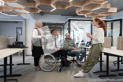 Image of Young group of business people brainstorming together in a startup space, discussing business projects, investments, and solving challenges.