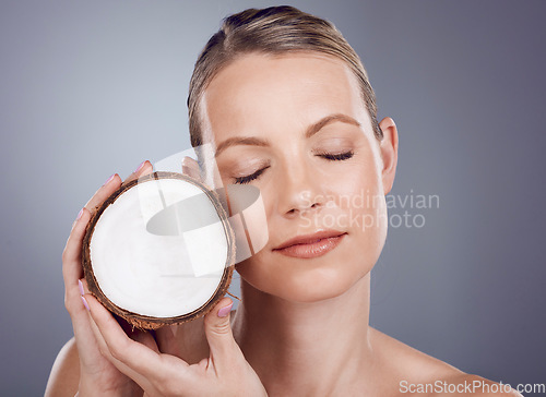 Image of Coconut, woman and skincare for wellness in studio, healthy food and aesthetic face benefits. Beauty model, tropical fruits for oil and natural cosmetics of facial nutrition, glow and spa background