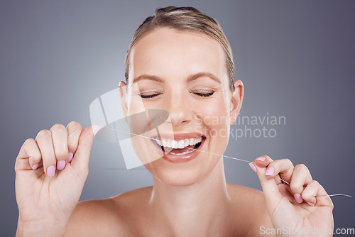 Image of Floss, teeth and smile of woman in studio for beauty, healthy dental hygiene and background. Happy female model, tooth flossing and cleaning mouth for treatment, fresh breath and oral maintenance