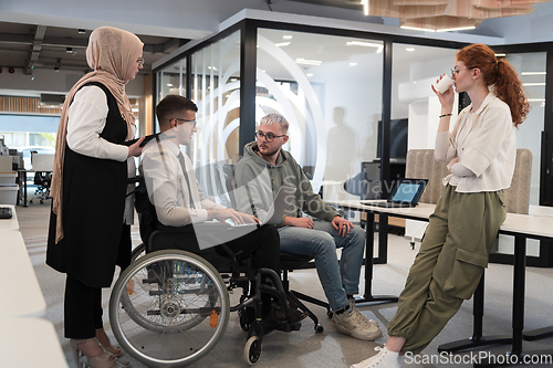 Image of Young group of business people brainstorming together in a startup space, discussing business projects, investments, and solving challenges.