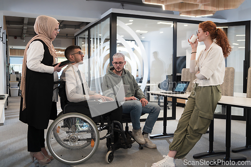 Image of Young group of business people brainstorming together in a startup space, discussing business projects, investments, and solving challenges.