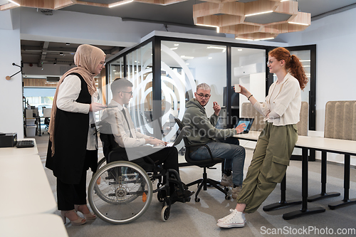 Image of Young group of business people brainstorming together in a startup space, discussing business projects, investments, and solving challenges.