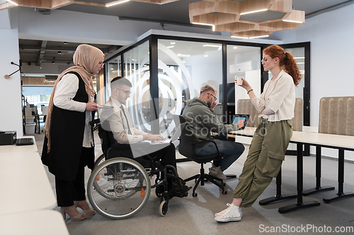 Image of Young group of business people brainstorming together in a startup space, discussing business projects, investments, and solving challenges.