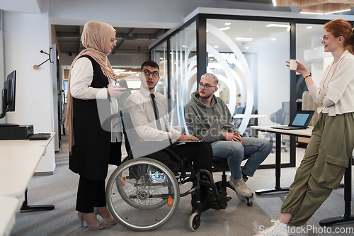 Image of Young group of business people brainstorming together in a startup space, discussing business projects, investments, and solving challenges.