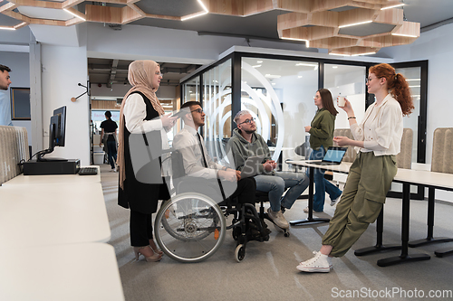 Image of Young group of business people brainstorming together in a startup space, discussing business projects, investments, and solving challenges.