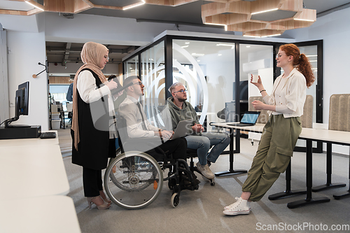 Image of Young group of business people brainstorming together in a startup space, discussing business projects, investments, and solving challenges.