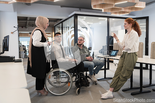 Image of Young group of business people brainstorming together in a startup space, discussing business projects, investments, and solving challenges.