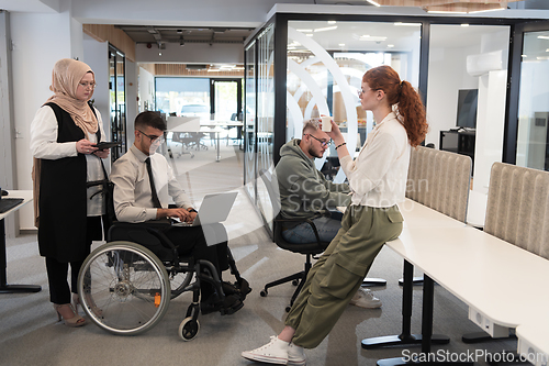 Image of Young group of business people brainstorming together in a startup space, discussing business projects, investments, and solving challenges.