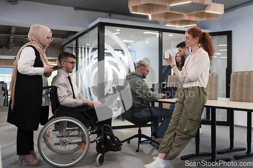 Image of Young group of business people brainstorming together in a startup space, discussing business projects, investments, and solving challenges.