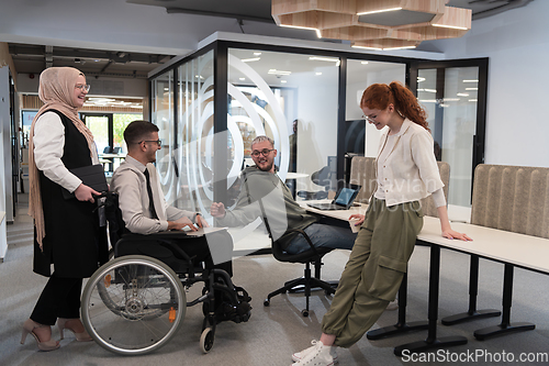 Image of Young group of business people brainstorming together in a startup space, discussing business projects, investments, and solving challenges.